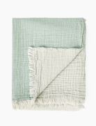 Aqua colored beach blanket with tassels folded